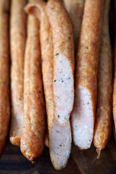 several sausages are lined up on a cutting board