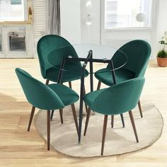 a glass table with four green chairs around it