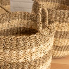 two woven baskets sitting on top of a wooden floor