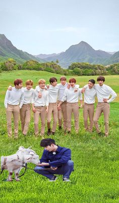 a group of young men standing next to each other on top of a lush green field