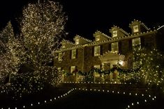 a large house covered in christmas lights at night