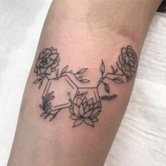 a black and white photo of flowers on the arm with an arrow in the middle