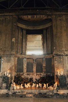 an old building with candles lit up in front of the window and windowsills