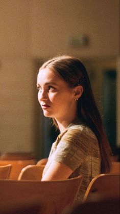 a woman sitting in a chair looking off into the distance