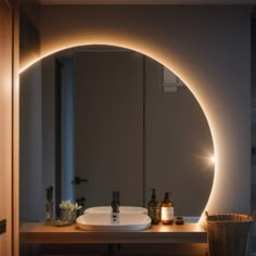 a bathroom sink under a round mirror with lights