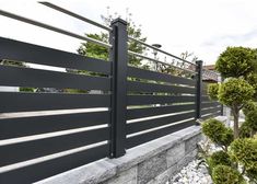 a black metal fence next to some bushes