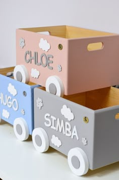 three wooden toy cars sitting on top of a white table