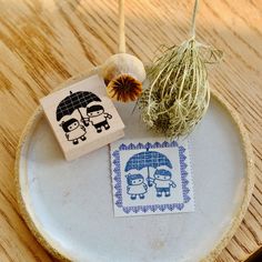 two rubber stamps sitting on top of a plate next to an air plant and mushroom