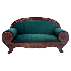 a green couch sitting on top of a wooden frame