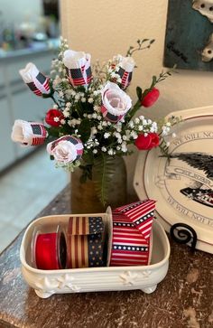 red, white and blue patriotic decorations in a container on a counter next to plates