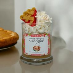 a glass jar filled with whipped cream and pie toppings on top of a table