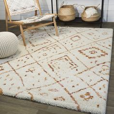 a white rug with an intricate design on the top and bottom in front of a chair