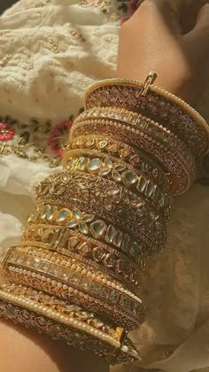 a woman's arm covered in lots of bracelets