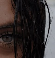 a close up of a person's face with wet hair on top of their head