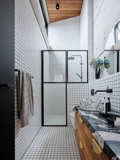 a bathroom with black and white tiles on the walls, flooring and counter tops