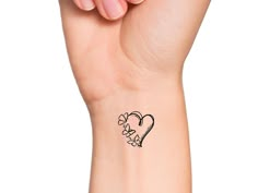 a woman's arm with a small heart tattoo on the left side of her wrist