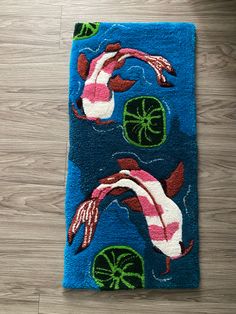 a blue rug with two koi fish and lily pads on top of wood flooring