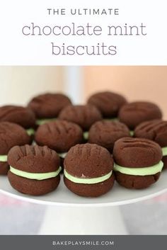 a white plate topped with chocolate cookies covered in frosting and green icing on top of a table