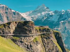 a mountain with a road going through it and snow capped mountains in the background,