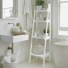 a white bathroom with a ladder shelf next to the sink