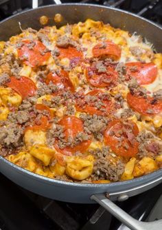 a skillet filled with pasta and meat covered in sauce