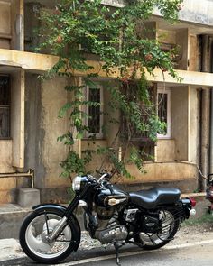 a motorcycle is parked on the side of the road in front of an old building