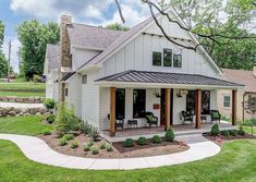 a white house sitting on top of a lush green field next to a tree and grass covered yard