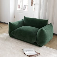 a green couch sitting on top of a white rug