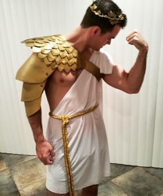 a man in a white and gold costume is flexing his muscles with golden chains around his neck