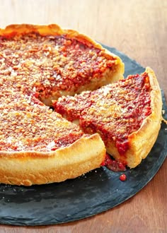 a deep dish pizza on a black plate