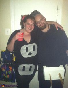 two people standing next to each other in front of a door and holding coffee cups