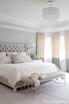 a bedroom with a large bed and chandelier