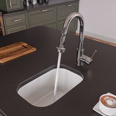 a kitchen sink with a faucet and coffee cup on the counter next to it