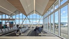 people are sitting in chairs at the airport terminal waiting for their luggage to be picked up