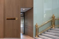 an open door leading to a hallway with gold railings and handrails on both sides