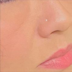 a woman's nose with a small white dot on the tip of her nose