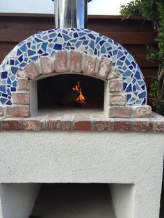 an outdoor pizza oven with blue and white tiles