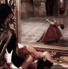 a woman laying on the ground in front of a mirror