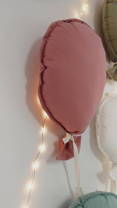 a round pillow with lights on the wall above it and other pillows in front of it