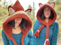 two women wearing knitted hats and scarves, one with a fox design on it