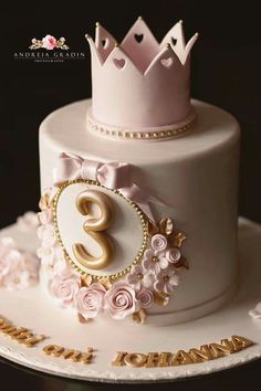 a three tiered cake with flowers and a crown on top