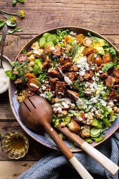 a salad with chicken, tomatoes, cucumbers and feta cheese in a bowl