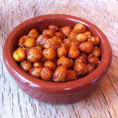 a brown bowl filled with nuts on top of a wooden table