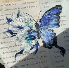 a butterfly painted on top of an open book