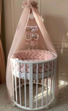 a baby crib with a pink canopy over it