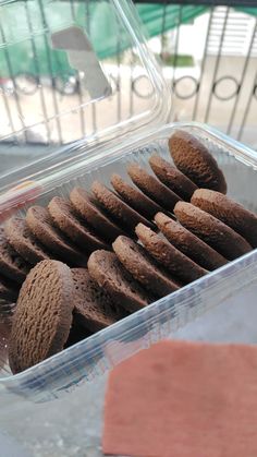 a plastic container filled with chocolate cookies on top of a table