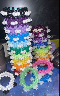 several bracelets are stacked on top of each other with different colors and shapes in them