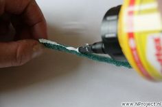 a person is using a drill to cut the cord off of a piece of string