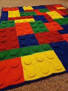 a multicolored crocheted blanket on the floor