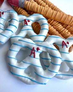 three decorated doughnuts sitting on top of a table next to a basket with an apple